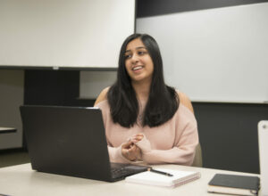 female student smiling in front of computer