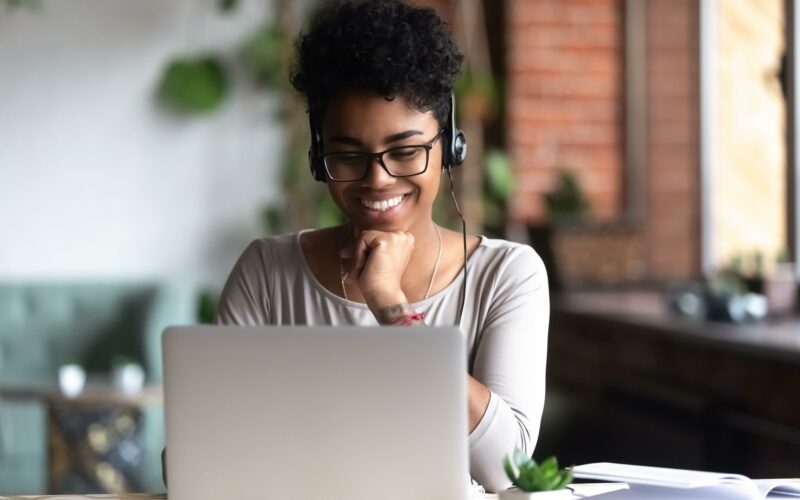 Black woman smiling at laptop screen