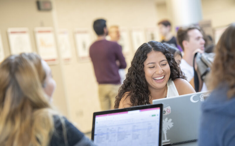 Female student laughing and looking at laptop