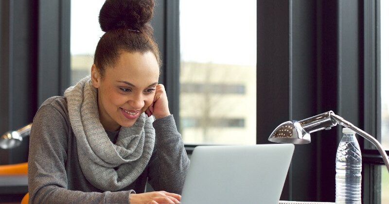 female student smiling and using laptop