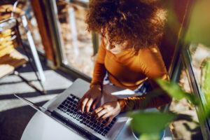 View from overhead of female professor typing on laptop