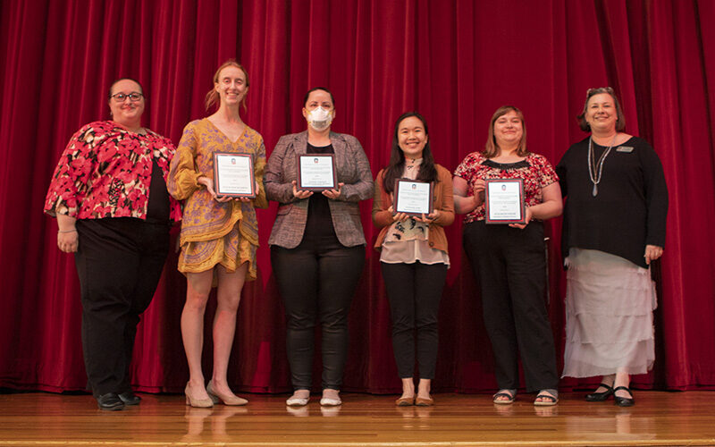 2022 NIU Outstanding TA Award recipients holding their plaques posing with Stephanie Richter and Kerry Wilks