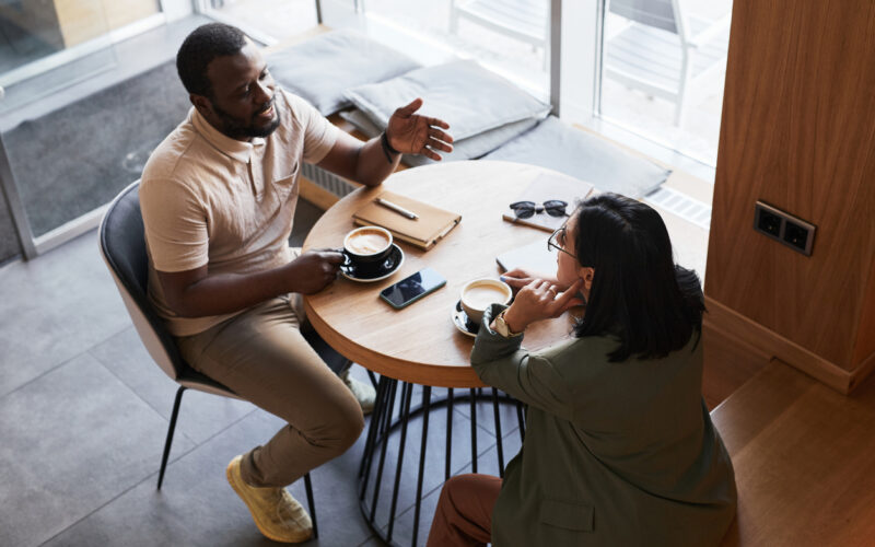 Man and woman chatting at table in coffee shop
