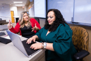 Two women sitting at desk with laptop on NIU Naperville Campus