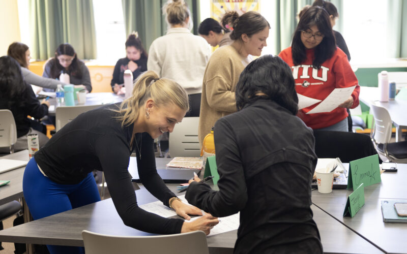 NIU students working in pairs and groups in a classroom