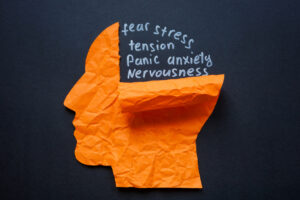 Torn paper head and the words fear stress and anxiety. Mental health struggles and emotional distress.