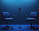 Two upholstered chairs facing each other with a standing microphone centered between them on a dimly lit stage, suggesting an interview or podcast setup.